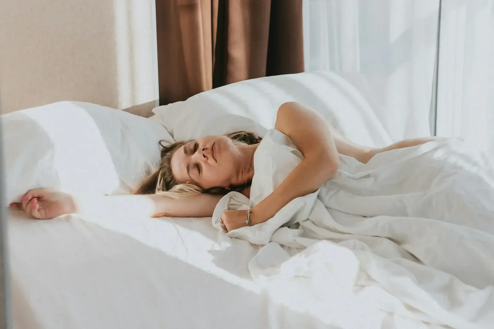 Guest sleeping in a white hotel bed